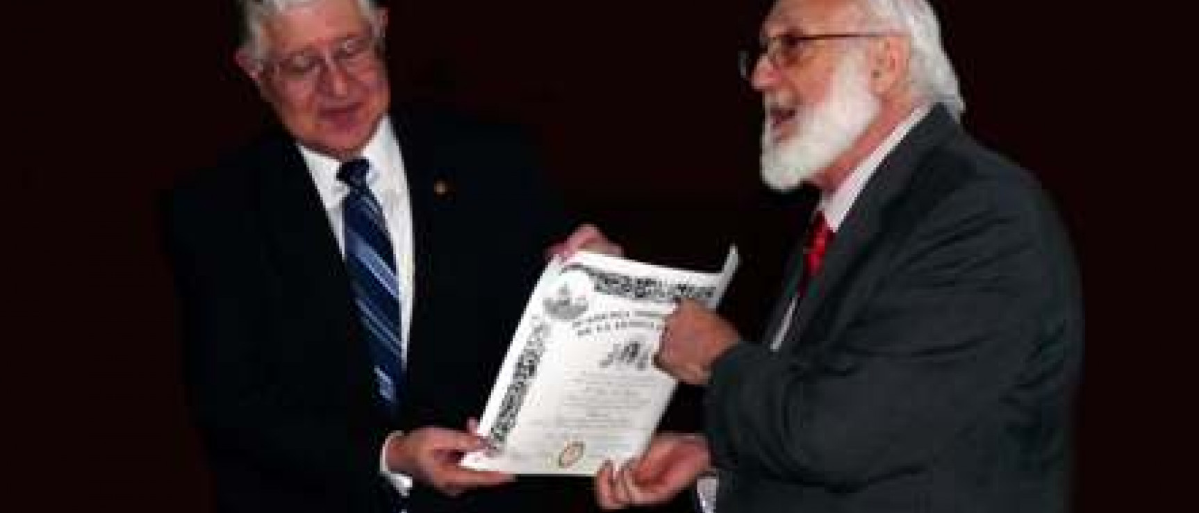 Gerardo Piña-Rosales hace entrega a Carlos E. Paldao del diploma de la ANLE.