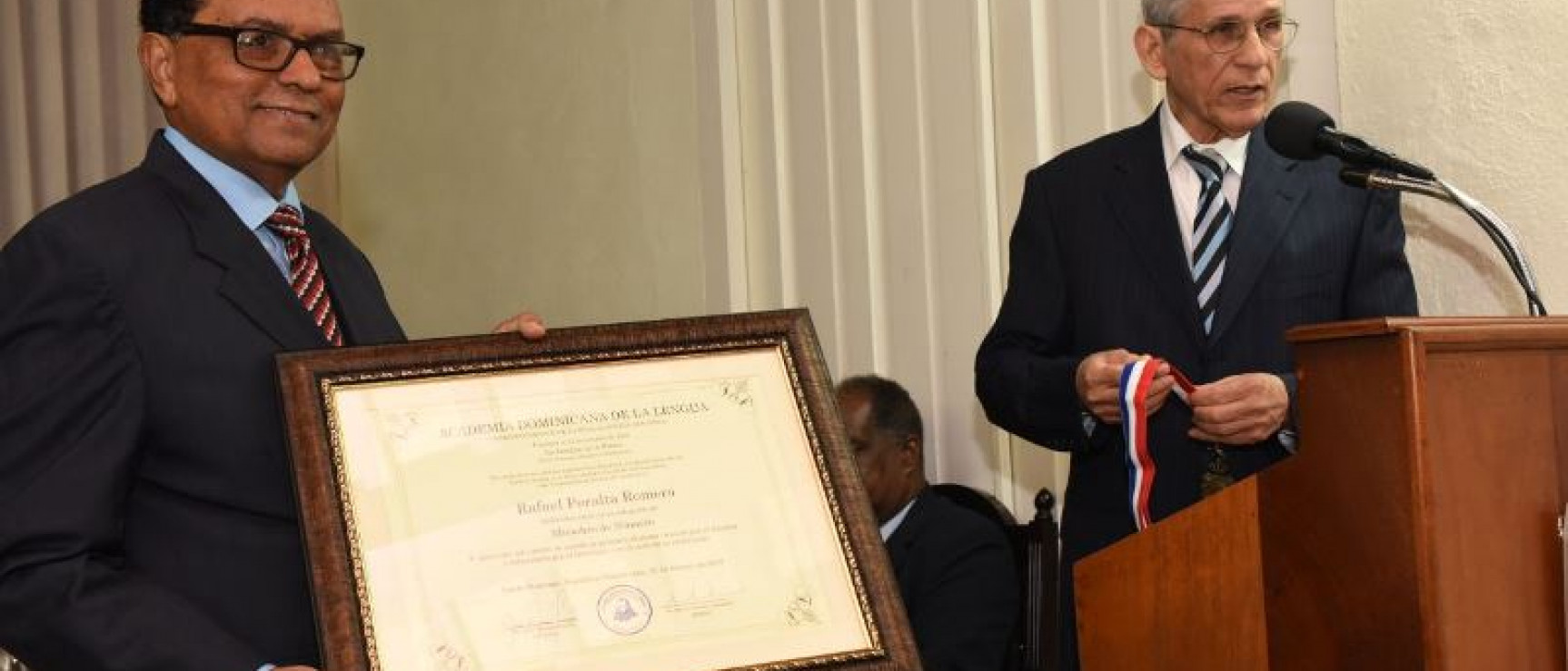 El director de la ADL, Bruno Rosario Candelier, entrega el diploma al nuevo académico. Foto: Al Momento.net